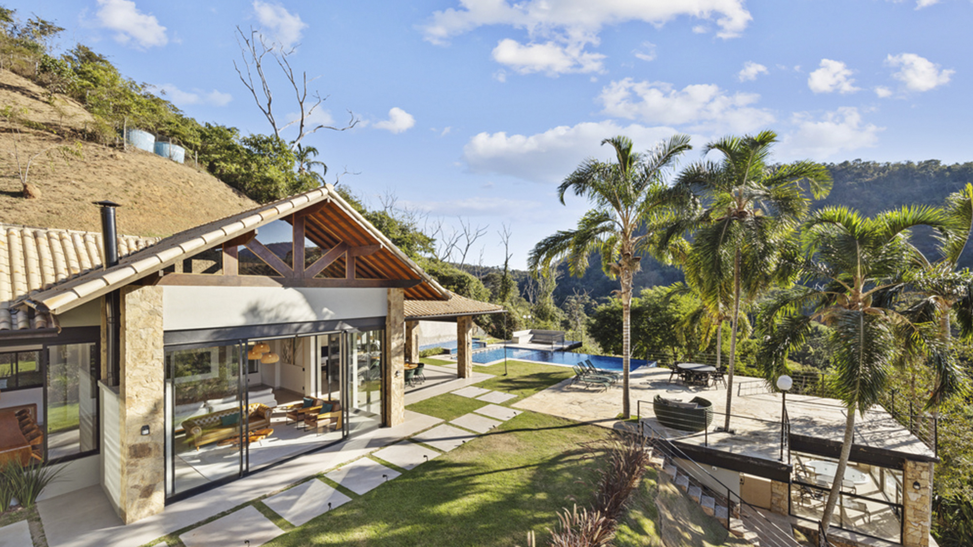 Casa residencial em condomínio de Itaipava com jardim e montanhas ao fundo representando qualidade de vida na Serra Fluminense.